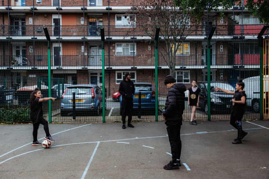 Che Clarke leads football practice with children on the estate
