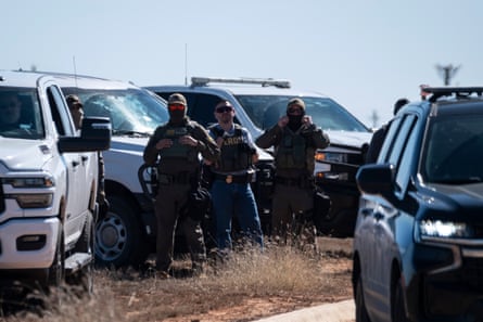 three masked men in militaristic uniform