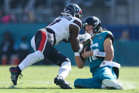 Trevor Lawrence takes a hard hit from Azeez Al-Shaair.