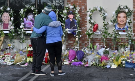 Two people embrace in front of memorial to victims of Monterey Park shooting
