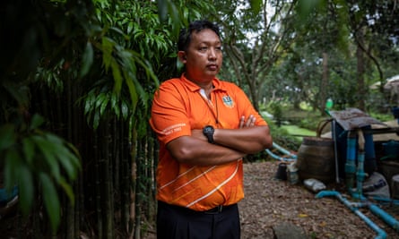 Manut Boonpayong, a farmer from Samut Songkhram, stands next to a water filtration system in his pomelo grove