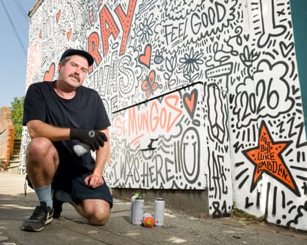 Artist Luke Embden with I Was Here, a public art installation in Bristol created in collaboration with charity St Mungo’s, transforming traditional graffiti-style name tags into artwork inspired by the stories of real people who have experienced homelessness.