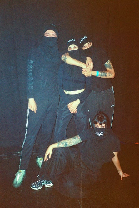 The four-piece band, wearing black casual clothes and black face coverings