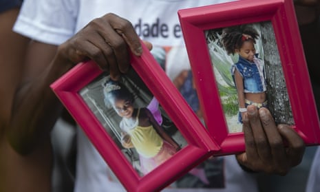 Ana Lúcia Silva Moreira, 38, mother of Emily Victoria Silva dos Santos, four, and aunt of Rebeca Beatriz Rodrigues dos Santos, seven holds photos of the two girls during a protest in Duque de Caxias, Rio de Janeiro state.