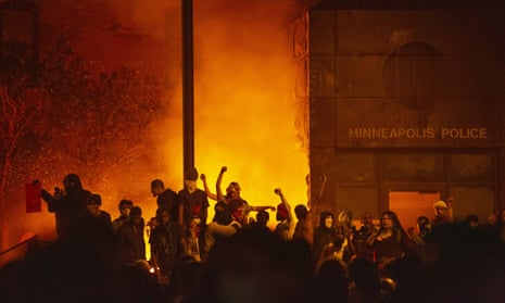Protesters raise their fists as the 3rd police precinct burns in Minneapolis, Minnesota.