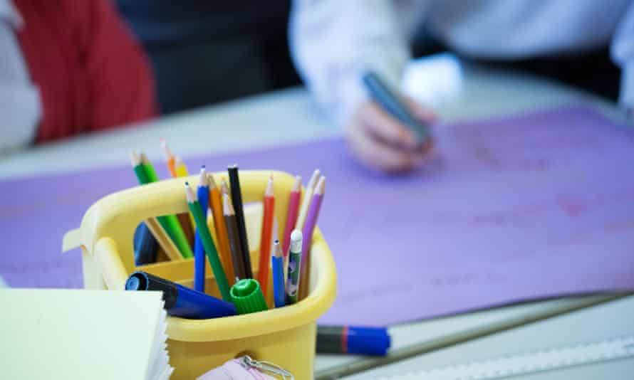 potloden en pennen in een emmer in een klaslokaal