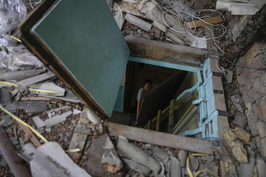 Liudmyla Voronina opens a skylight window on the roof of her house roof as she stands inside her home that was damaged by attacks in Irpin, on the outskirts of Kyiv, Ukraine.
