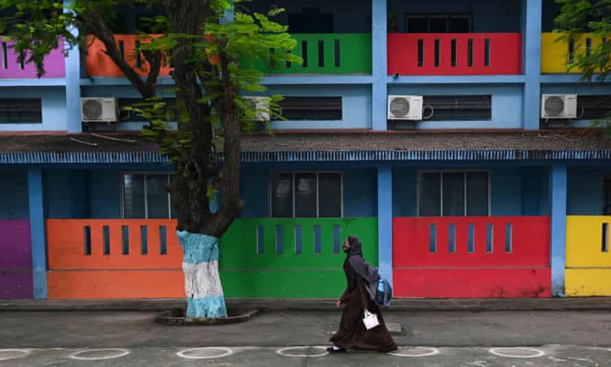 A student arrives to attend classes at a school at a school in Chennai after the state government relaxed restrictions for schools