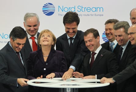 Former German Chancellor Angela Merkel and former Russian President Dmitry Medvedev turn a wheel to symbolically start the flow of gas through the Nord Stream Baltic Sea gas pipeline on November 8, 2011 in Lubmin, Germany.