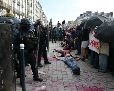 Parents lay down in front of riot police during a protest action on the sidelines of a demonstration of high-school students as part of a nationwide protest movement over learning conditions in Rennes.