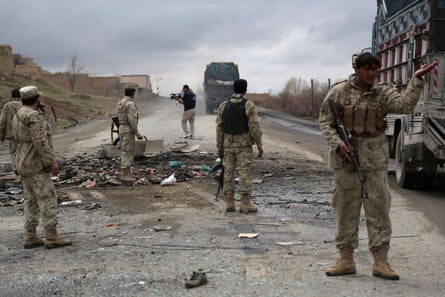 2013: Afghanistan security forces stand guard after a roadside bomb exploded under an Afghan bus, killing nine in an attack blamed on Taliban militants.