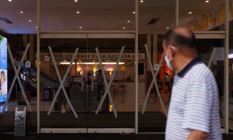 HONG KONG-CHINA-WEATHERA man walks past a shopping mall with masking tape in Tseun as a precaution for the approaching Typhoon Talim in Hong Kong on July 16, 2023. (Photo by May JAMES / AFP) (Photo by MAY JAMES/AFP via Getty Images)