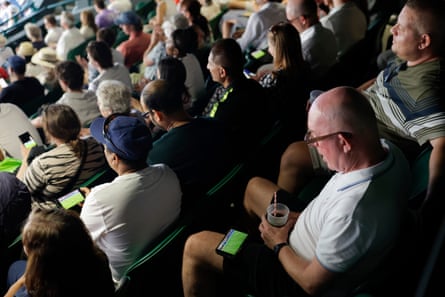 A spectator watches the England v the DRC World Cup match on his phone near the back of Court One
