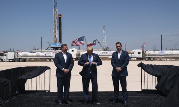 Donald Trump adjusts his jacket as he stands with Double Eagle Energy co-CEOs Cody Campbell, left, and John Sellers, right before viewing the Double Eagle Energy oil rig in Midland, Texas.