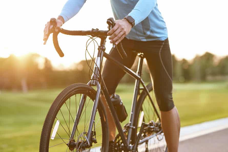 Man on a bike with the sun setting in the background