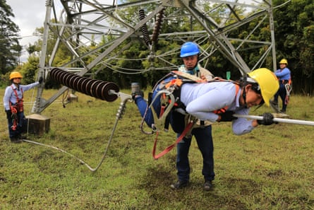 An apprentice learns how to move along a cable, near the ground. Mastering this technique is a difficult aspect of the training, even after apprentices have conquered their fear of heights.