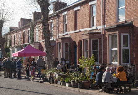 Victorian terraced street with plants and people chatting, Granby Four Streets, Liverpool