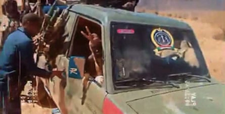 Video still showing armed men in a truck with a variation of the RSF emblem on the windscreen.