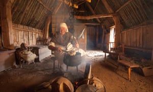 A woman in traditional costume cooking at the Highland Folk Museum, Newtonmore.