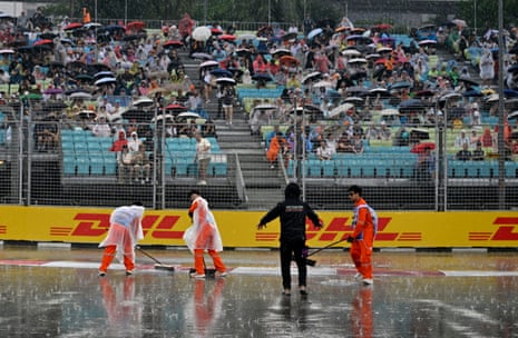 Marshals dry the track to prepare for the sprint race.
