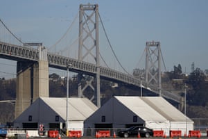 Tents from a Covid testing site in San Francisco sit in front of the San Francisco-Oakland Bay bridge.