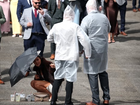 Racegoers wear rain ponchos at Aintree.
