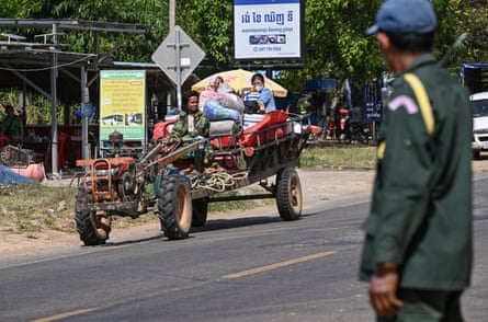 A police officer stands as residents evacuate following clashes along the Cambodia-Thailand border in Siem Reap province