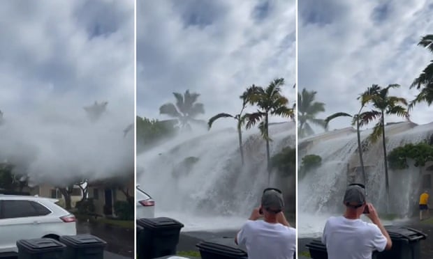 Waves crash over two-story buildings in Hawaii.