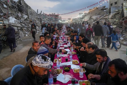 A table, surrounded by the rubble of destroyed homes and buildings, for iftar, the fast-breaking meal, on the first day of Ramadan in Rafah, southern Gaza Strip, 1 March