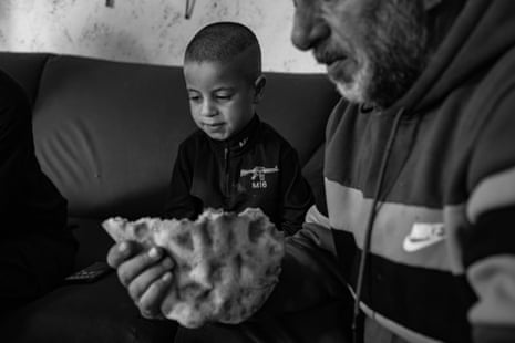 A man and a child eat bread