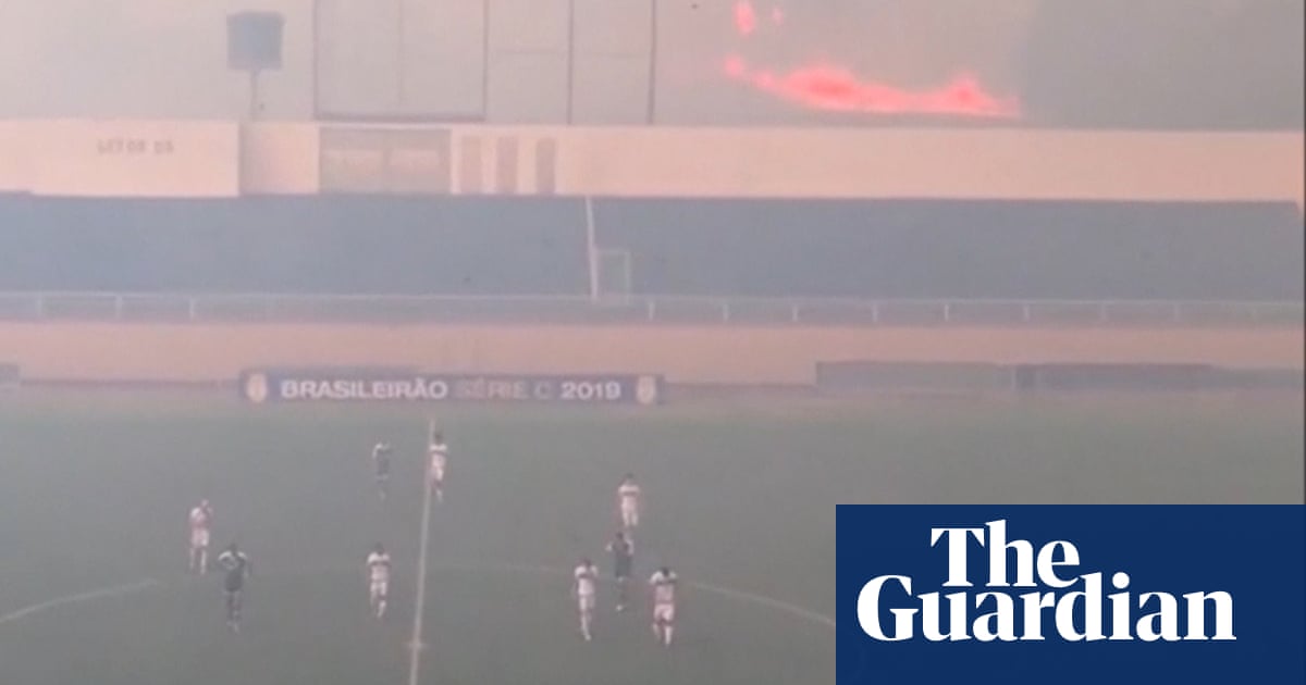 Brazilian football match halted due to nearby wildfire – video