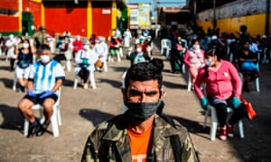 Employees of the Ciudad de Dios market wait to be tested by workers of the health ministry in Lima
