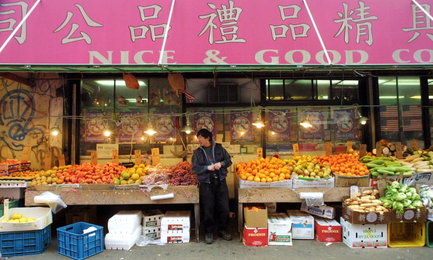 A vendor stands at an empty fruit and vegetable stand in Chinatown, New York City, in November 2001.