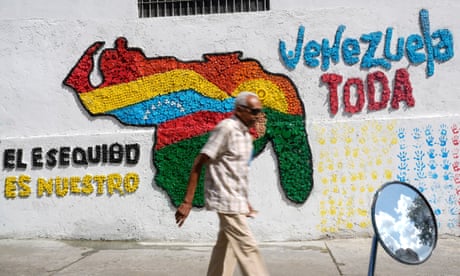 A man walks in front of a mural of the Venezuelan map with the Essequibo territory included, in Caracas, Venezuela, Wednesday, Nov. 29, 2023. Venezuelans will attempt to decide the future of the Essequibo territory, a large swath of land that is administered and controlled by Guyana but claimed by Venezuela, via a referendum that the Venezuelan government put forth in its latest attempt to claim ownership, saying it was stolen when a north-south border was drawn more than a century ago. (AP Photo/Matias Delacroix)