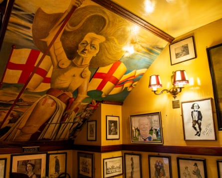 A mural on a restaurant wall with framed pictures lining it