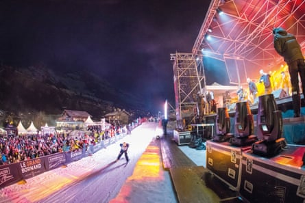 Colourful image of skier and stage with performance going on and spectators on the left