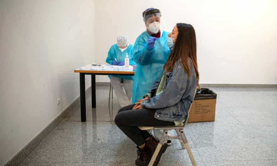 A health care worker performs a rapid COVID-19 disease antigen test on a student at a temporary testing point at Rey Juan Carlos University in Mostoles, near Madrid.