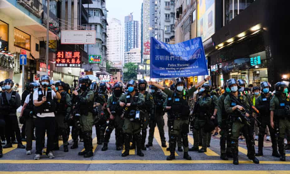 Hong Kong riot police hold up warming sign during an unauthorized rally on September 6