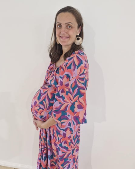 Woman in colourful dress holding her baby bump