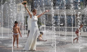 A bride cools off in Kiev, Ukraine, where temperatures reached over 36C.