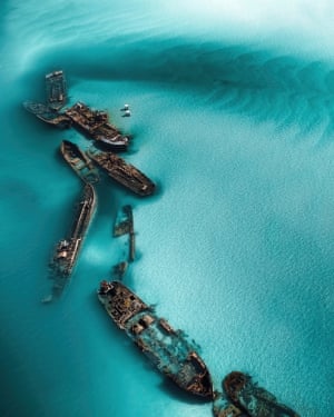 Aerial category winner ‘Textures of Tangalooma’ shows an aerial view of sinking boats on a blue ocean