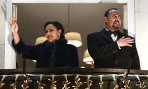 Abiy Ahmed and his wife Zinash Tayachew wave from the balcony of the Grand Hotel in Oslo on 10 December during a torch parade in honour of his Nobel peace prize.