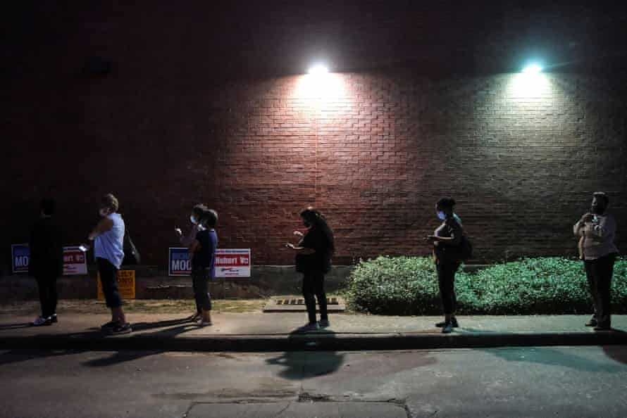 People wait in line to cast their ballots in early voting in Houston, Texas, on 13 October.