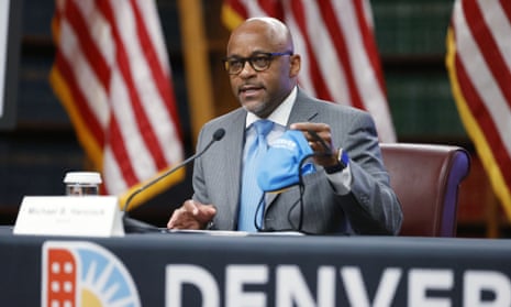 Denver’s mayor, Michael Hancock, holds up a face mask during a news conference in Colorado on 5 May. 