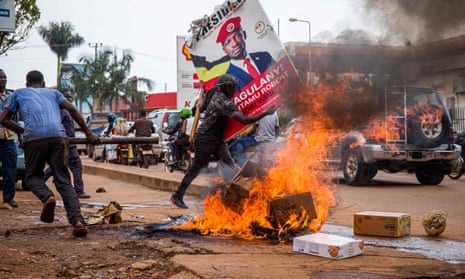 A supporter of Bobi Wine carries his poster as they protest against his arrest.