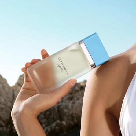 a model holding a bottle of dolce and gabbana light blue perfume