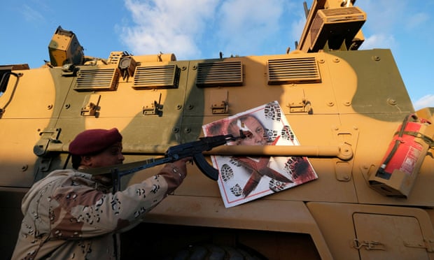 A militiaman, under Khalifa Haftar, with a Turkish military armoured vehicle, which was confiscated during clashes in Benghazi, Libya, in January.