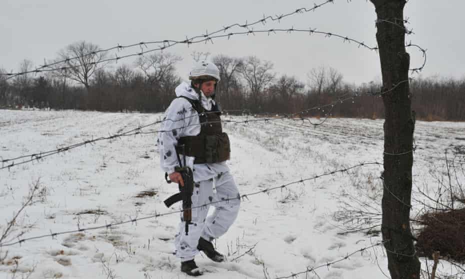 A service member of the Ukrainian armed forces is seen behind barbed wire at combat positions near the line of separation from Russian-backed rebels near Horlivka in the Donetsk region.