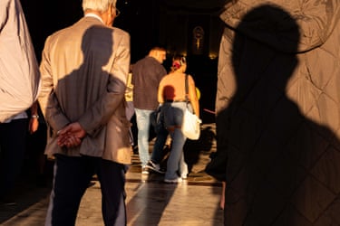 Shadows fall on the backs of people at a cathedral entrance