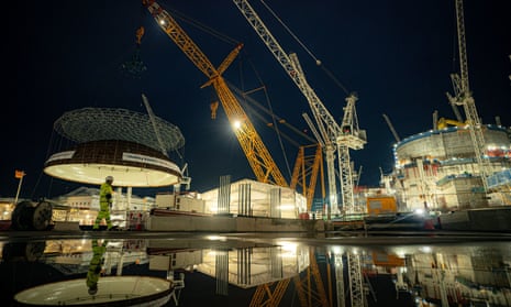 Construction of Hinkley Point C with pictures of cranes lit up against a night sky.